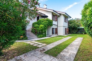 A two-story house with a garden pathway leading to the entrance.