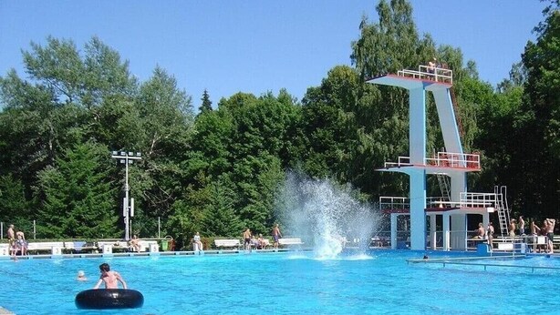 A swimming pool with a diving platform and a sign in German. - Bright, modern, large vacation apartment on a south-facing slope in a climatic health resort (Friedrichroda)