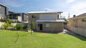 A two-story residential building with a flat roof, a small front yard, and a satellite dish. - Wallace Waves in Mollymook (Mollymook)