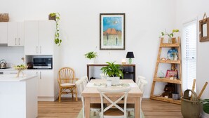 A modern kitchen with white cabinets, a microwave, and a basket of green apples. - Break Away in Dolphin Point (Dolphin point)
