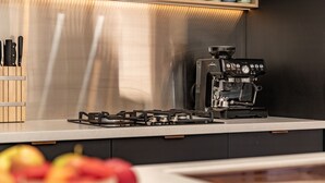 A kitchen with a gas stove, a coffee machine, and a knife block.