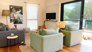 Relax in this stylish living room with a comfortable sofa, armchair, and flat-screen TV.