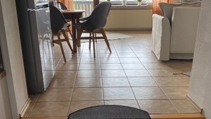 Un apartamento moderno con comedor, cocina y sala de estar con sofá y televisor.