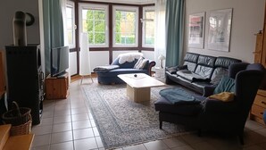 Olohuone, jossa on takka, sohva, sohvapöytä ja televisio.