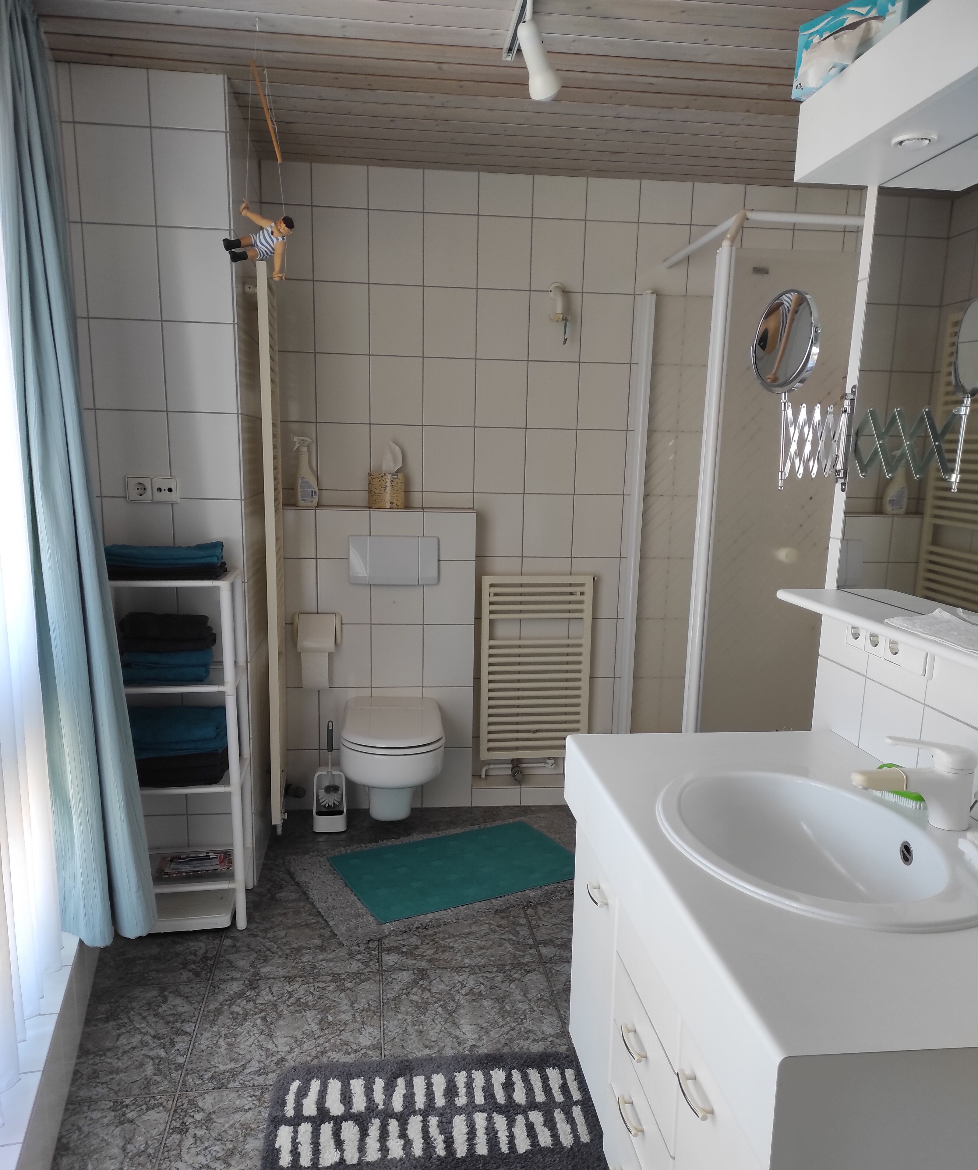 A bathroom with a toilet, sink, and shower area.