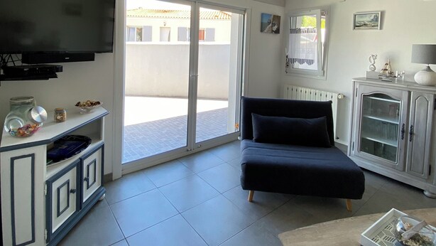 A living room with a TV, sofa, and a cabinet. - Vacation home in Meschers quiet area (Meschers-sur-Gironde)