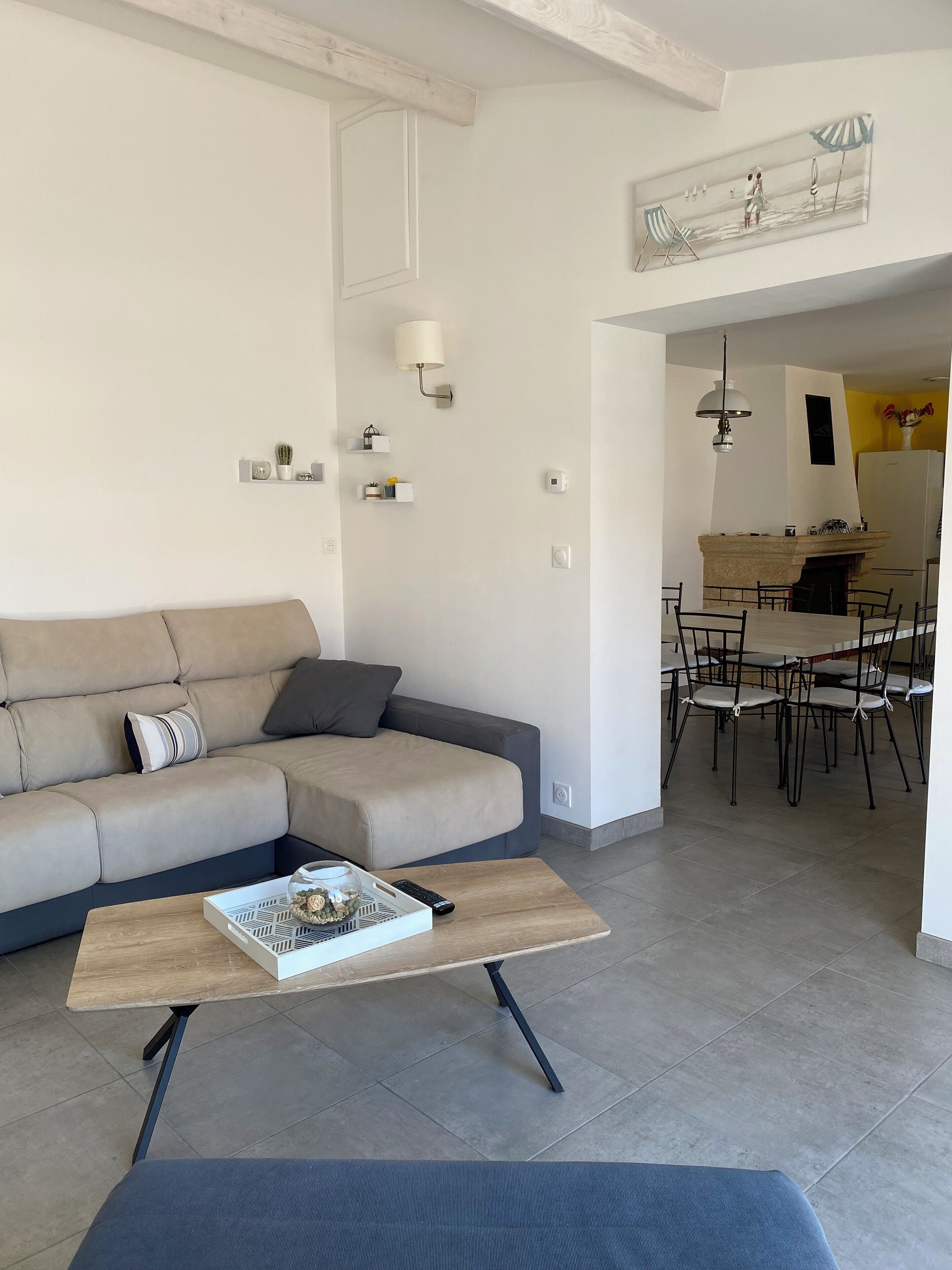 A modern living room with a sofa, coffee table, and dining area.