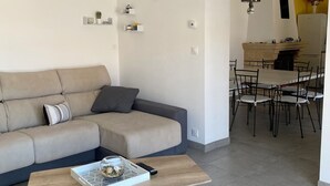 A modern living room with a sofa, coffee table, and dining area. - Vacation home in Meschers quiet area (Meschers-sur-Gironde)