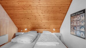 A bedroom with two beds, wooden ceiling, and a poster of Rome's landmarks. - 2 bedroom lovely home in Rømø (Rømø)