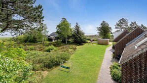 A residential property with a grassy yard, a brick house, and a wooden deck. - 2 bedroom lovely home in Rømø (Rømø)