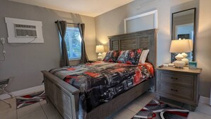 Ein Schlafzimmer mit Bett, Nachttischen, einer Lampe und einem Fenster mit Vorhängen.