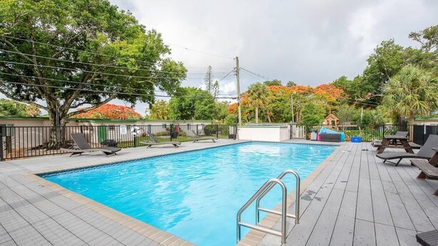 Ein rechteckiger Pool mit einer Metallleiter, umgeben von einer Holzterrasse.