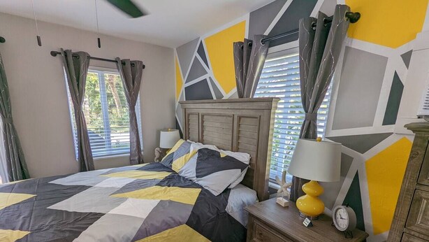 Une chambre à coucher avec un lit, une table de chevet, une lampe et une commode.