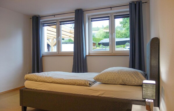 A single bed with a headboard, two windows with curtains, and a view of the outside. - Lovely home in Schmallenberg with WiFi (Schmallenberg)