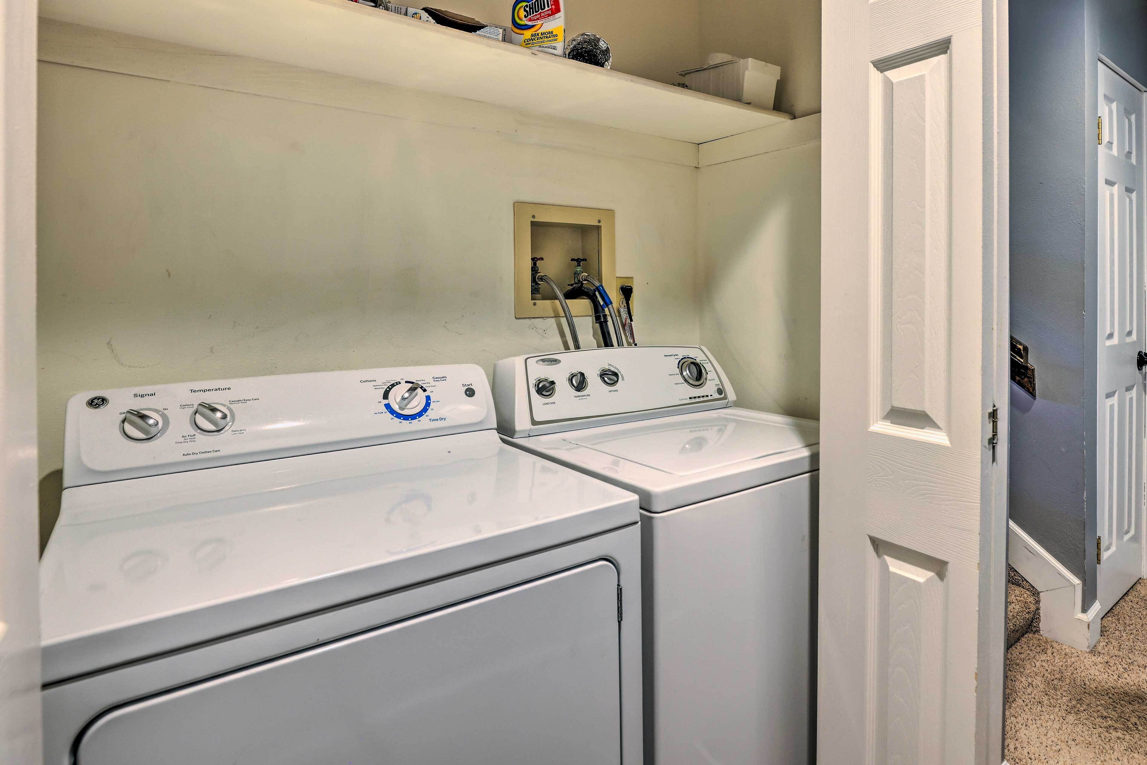 A laundry room with two front-loading washing machines and a utility sink.