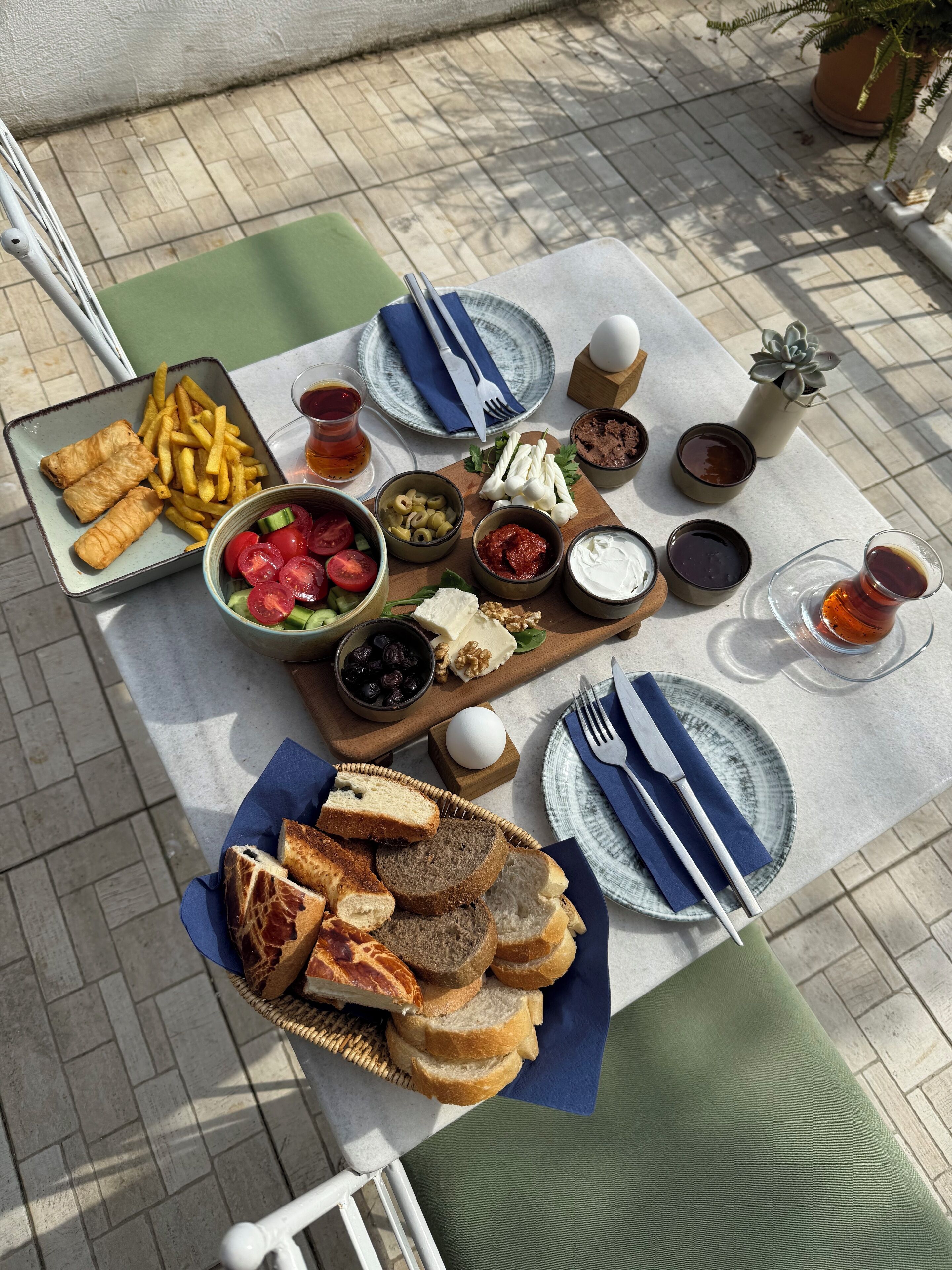 A picnic setup with various foods and drinks on a table.