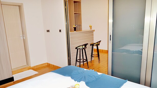 A hotel room with a bed, a breakfast tray, a small kitchen area, and a sliding door closet.