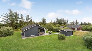 A modern lodge with a large open patio, a separate dining area, and a small utility shed. - Amazing home in Brovst with kitchen (Brovst)