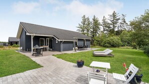 A modern house with a covered patio, a barbecue area, and a lawn with outdoor furniture. - Amazing home in Brovst with kitchen (Brovst)