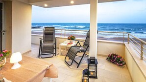 A balcony with two chairs, a table, and a lamp. The balcony overlooks the ocean. - Lovely home in Kaukana with WiFi (Kaukana)