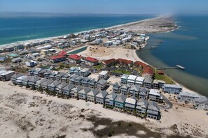 Vue aérienne d’un hôtel situé sur la côte, composé de plusieurs bâtiments, avec une plage et un port de plaisance.