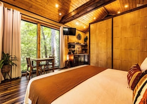Ein Schlafzimmer mit einem großen Bett, einem Esstisch und einer Küchenzeile.