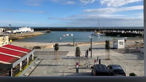 Blick auf die Küste mit einem Yachthafen, einem Restaurant und einem Parkplatz.