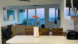 A modern kitchen with a central island, a dining area with a view, and a ceiling fan.