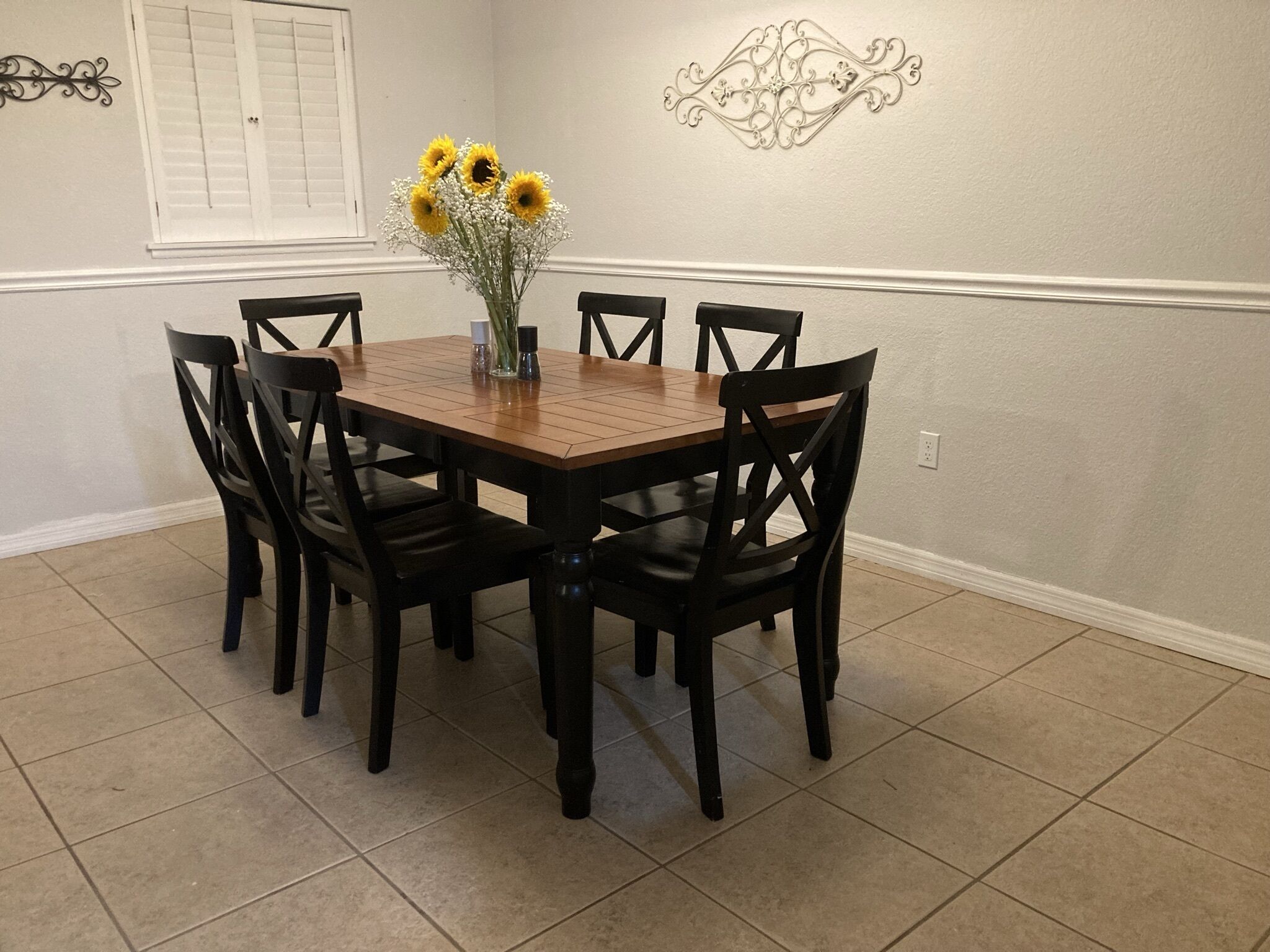 Uma sala de jantar com uma mesa de madeira e seis cadeiras.