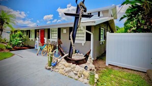 A house with a front yard featuring a large anchor sculpture, bicycles, and a red door. - Waterfront Home with Private Dock and Kayaks 4 Bedroom 2 Bath (Bradenton)