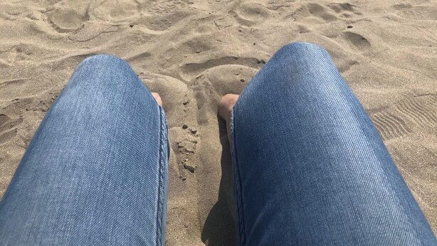 Una spiaggia sabbiosa con impronte che conducono all'acqua.