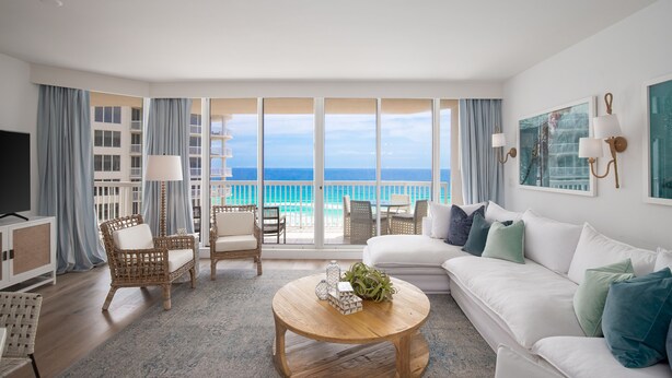 A spacious living room with a large window overlooking a balcony and the sea. - Ocean Aire Gulf Front Condo, Resort, Pool (Destin)