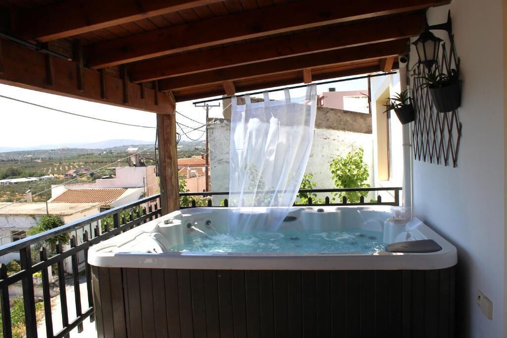 Un jacuzzi en un balcón con vistas al campo.