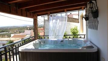Un jacuzzi en un balcón con vistas al campo.