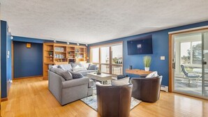 Een moderne woonkamer met een grijze bank, een salontafel en een boekenkast.