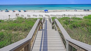 A wooden boardwalk leading to a beach with clear turquoise waters and a sandy shore. - Gulf Front With Private Pool- Serenity Blue by Royal Destinations (Santa Rosa Beach)