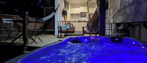 Tinaco con iluminación azul, una hamaca y una terraza de madera.
