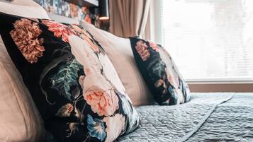 A bed with floral-patterned pillows and a quilted bedspread.