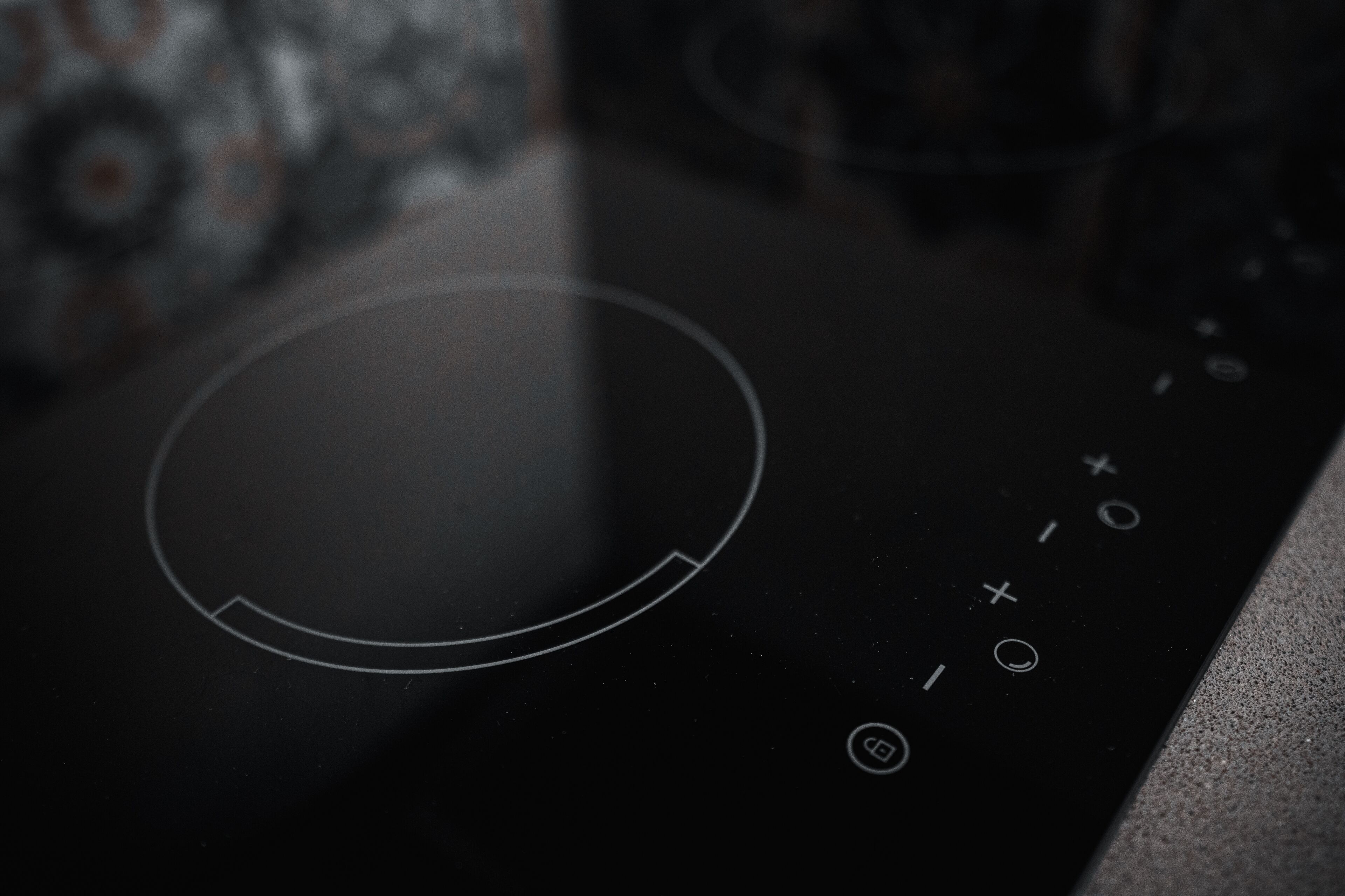 Primer plano de un panel de control negro con un dial circular y un teclado numérico.