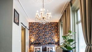 A cozy room with a wooden floor, a round table with a remote control, a potted plant, and a decorative ceiling light. - The Hogg House (Groningen)