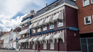 A hotel with a classic facade, multiple balconies, and a prominent sign. - The Aquarium (Groningen)