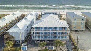 Un hôtel situé en bord de mer, composé de plusieurs bâtiments, dont une structure imposante à la façade bleue et au toit plat.