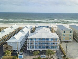 A beachfront hotel with multiple buildings, including a prominent structure with a blue facade and a flat roof. - Newly Updated Beach Front Retreat (Gulf Shores)