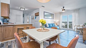Une cuisine moderne avec un coin repas, un salon doté d’un canapé et un balcon.