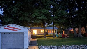 Ein Seehaus mit Steg, Garage und einem Rasen.