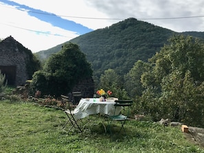 Mesa al aire libre con vista a una montaña y una construcción de piedra.