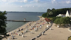 Une plage avec des cabanes de plage, une jetée et une église.
