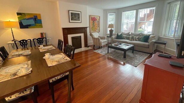 A living room with a fireplace, dining area, and a sofa set.