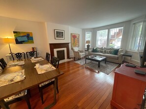 Una sala de estar con chimenea, comedor y un conjunto de sofás.