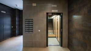 A modern elevator with a digital display, a sign indicating the floor, and a control panel with buttons.